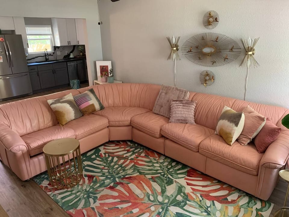 Custom pink leather sectional couch holds two adults or four dogs for napping
