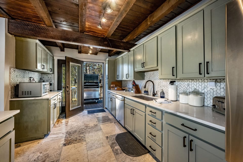 Kitchen opens to the large deck with a RecTeq pellet grill and seating. 