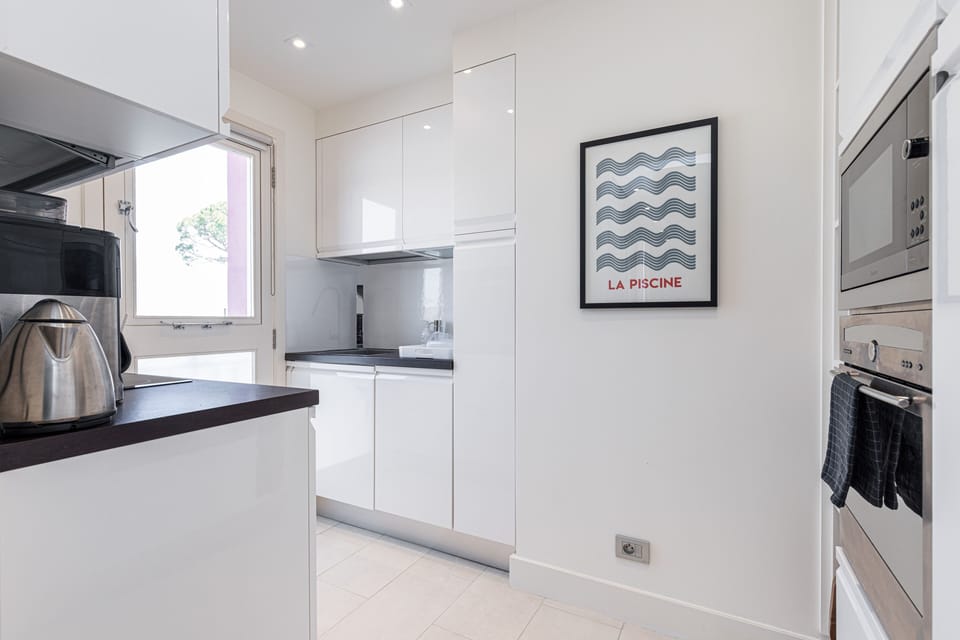 The fully equipped kitchen with a door that opens onto a view of the port.