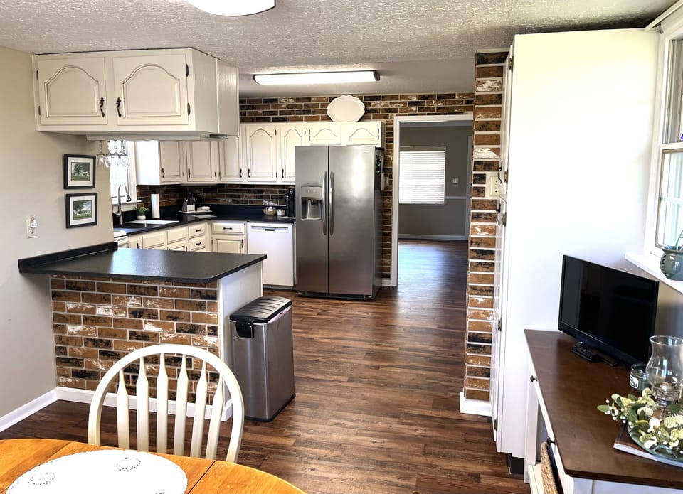 Newly remodeled kitchen with large farmhouse style sink and granite countertops 