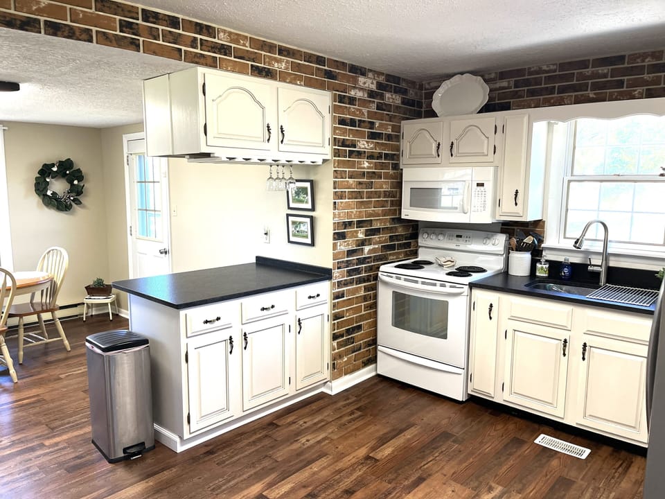 Newly remodeled kitchen with rough cut granite countertops and TV
