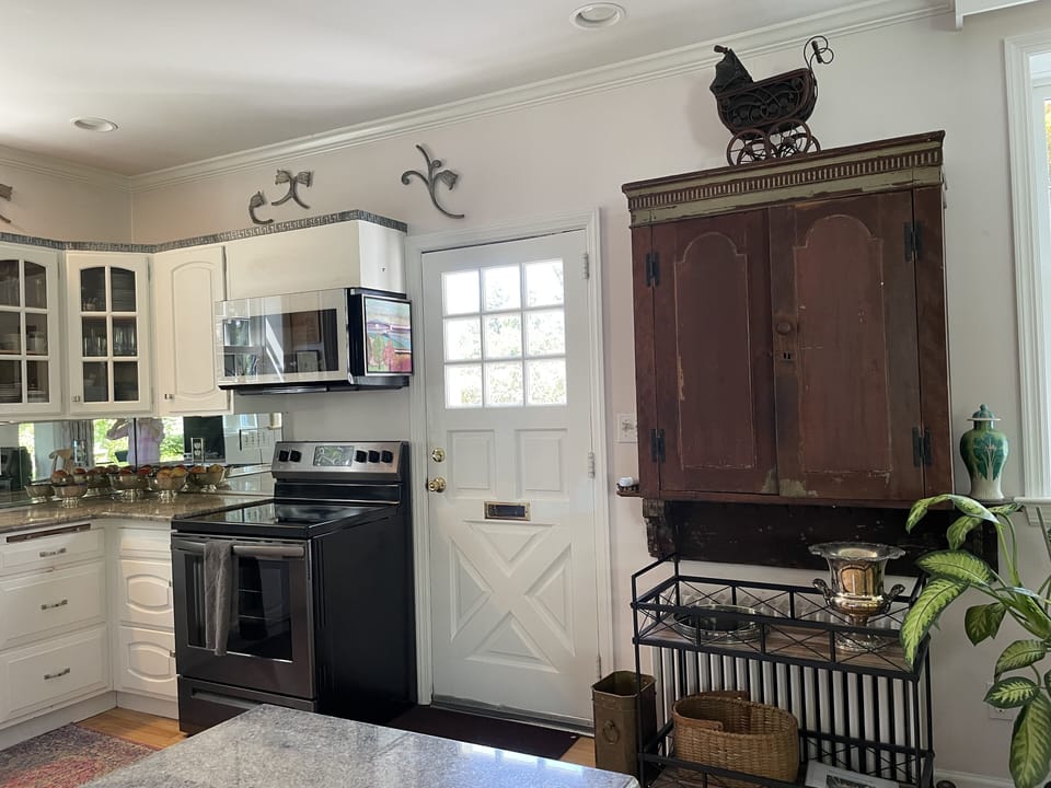 Kitchen, view of the antique cabinet with glassware & bar cart.  