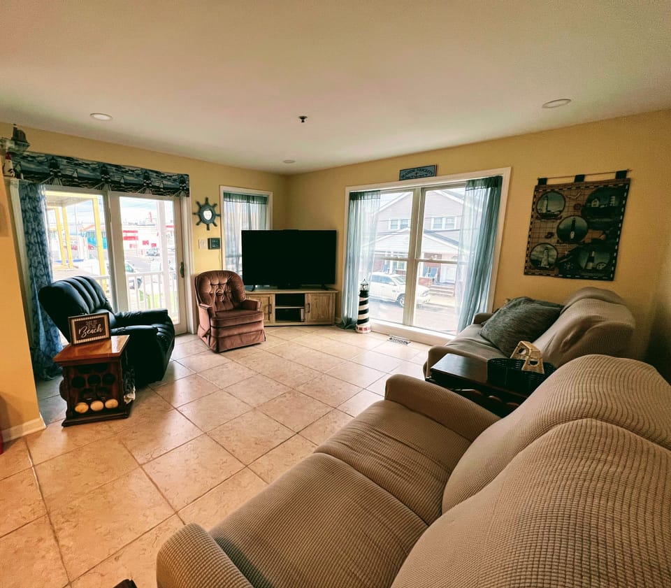 Spacious living room with all reclining seating and large smart TV.