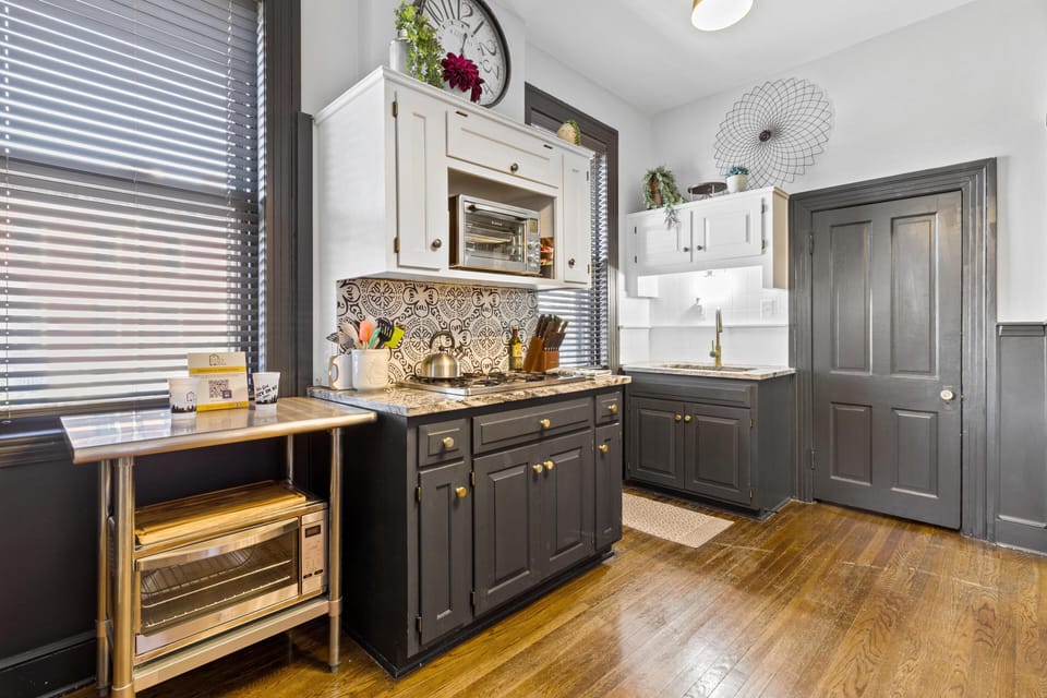 Thoughtfully organized cooking area with custom cabinetry, stylish backsplash, and convenient toaster oven nook—blending historic character with everyday functionality.