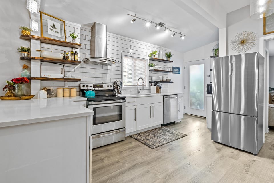 Cook with ease in this stylish Hyde Park kitchen featuring stainless steel appliances, subway tile, and warm natural accents. 