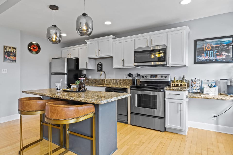 Modern full kitchen with granite island seating, stainless steel appliances, and bar stools—perfect for meals at home just steps from the Nelson-Atkins Museum and a short walk to the Plaza.