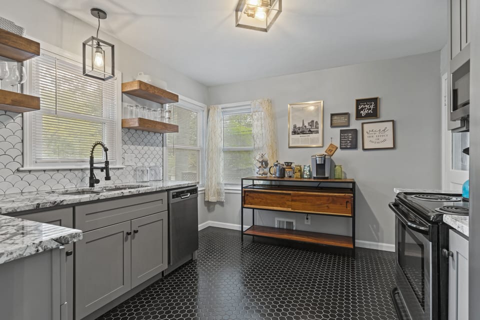 Stylish open shelving and marble-look countertops create a clean, modern space for meal prep throughout your 30+ night stay.