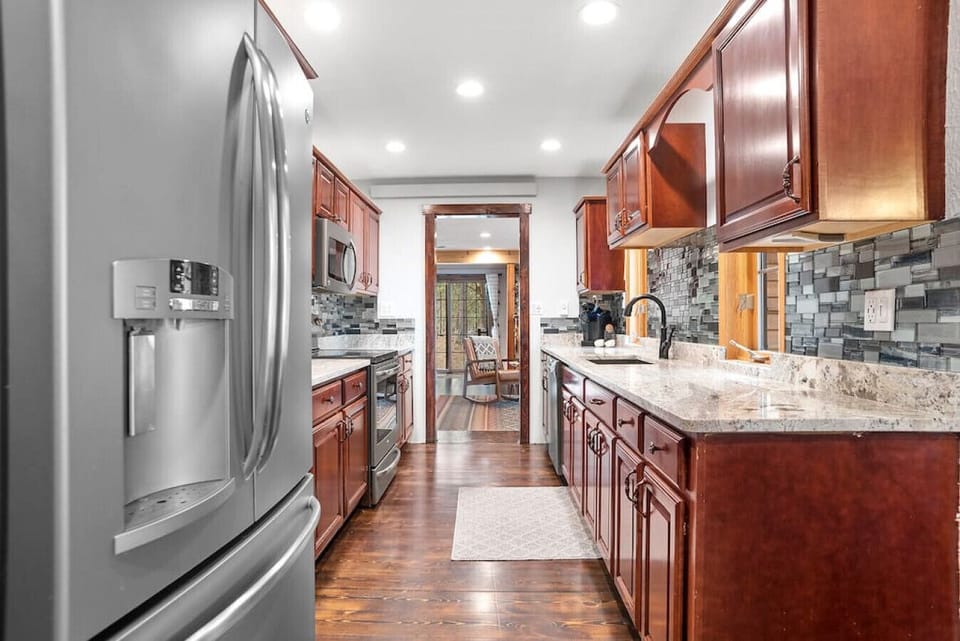 With plenty of room to move around, this kitchen includes a large sink area and easy access to all amenities. Its smart layout and sleek design make meal prep effortless for any guest.