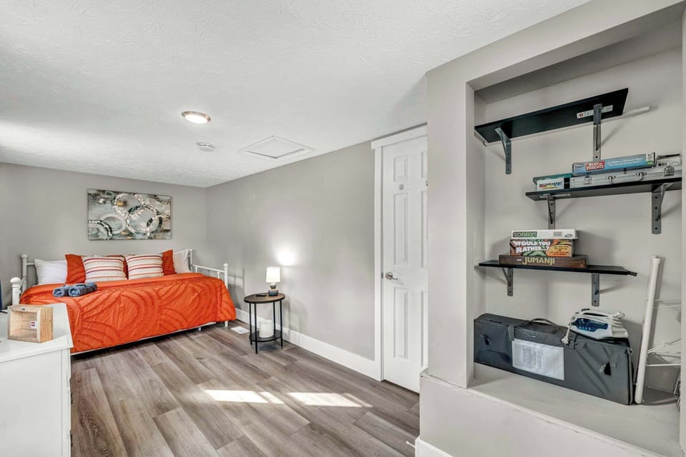 Bedroom  w/ wood floors, open shelving & a bright, functional layout.
