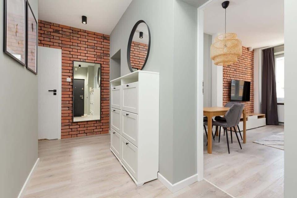A hallway leading to a dining area with modern furniture, showcasing a clean and open design.