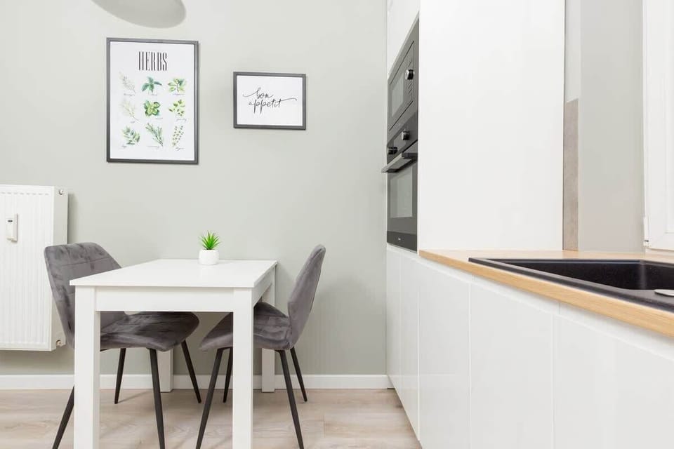 A small dining table set against a wall with framed artwork, adding a stylish touch to the dining area.