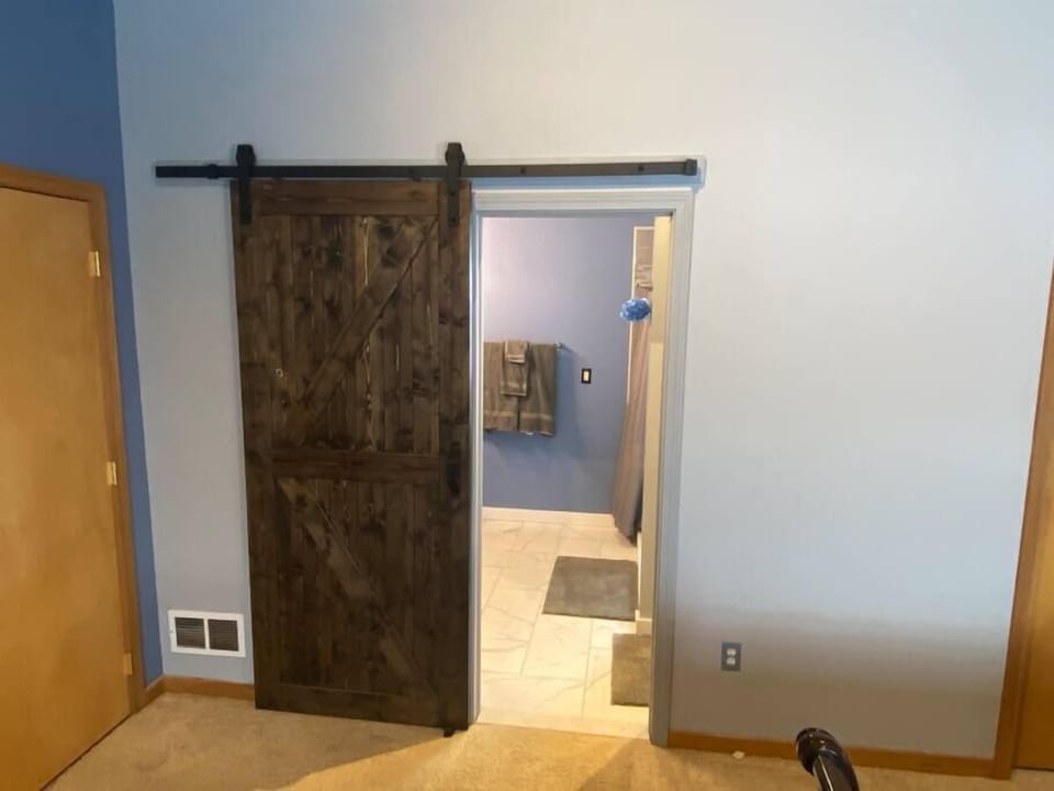 Master bedroom barn door entry into master bathroom