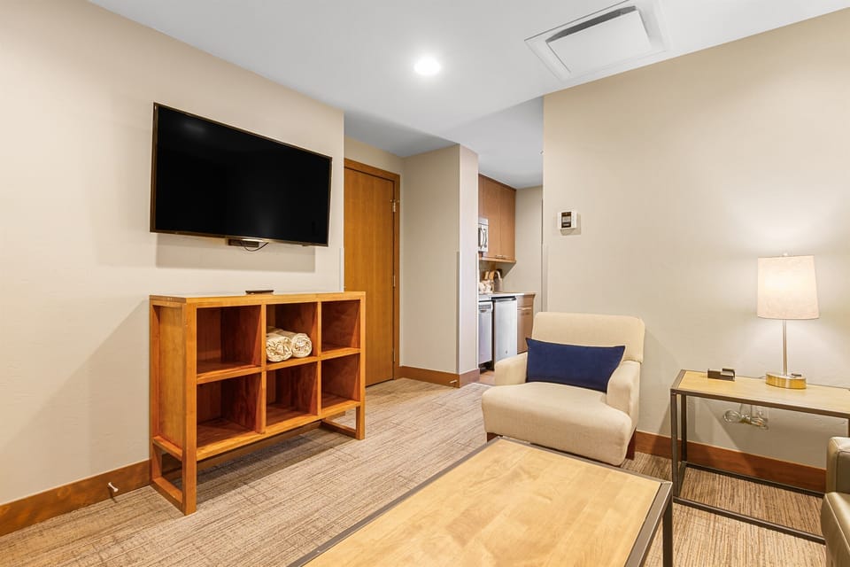 Cozy living area featuring a comfortable armchair, flat-screen TV, and stylish furnishings. Perfect for relaxing after a day of exploring.