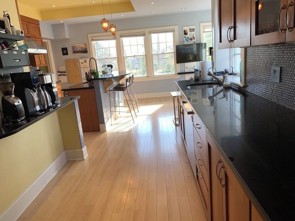 gourmet kitchen with bar area for gathering + eat-in / living space