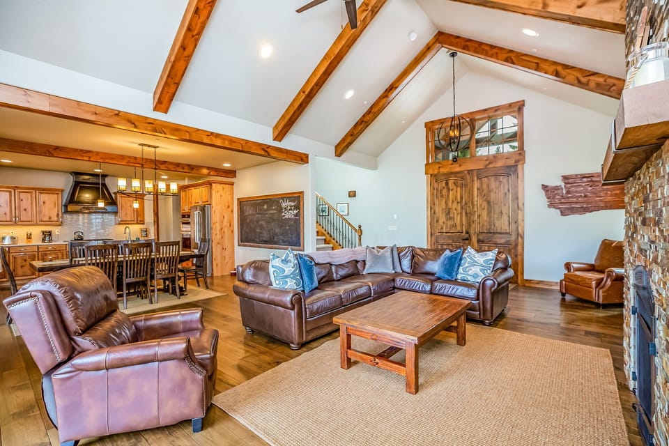 Welcoming foyer framed by soaring ceilings, wood beams, and natural wood accents