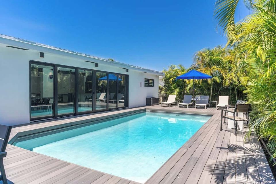 "Stunning heated pool with deck loungers and lush tropical palms – your private Florida paradise! This contemporary vacation rental features modern design, outdoor entertainment space, and resort-style amenities for the ultimate sunny getaway!"