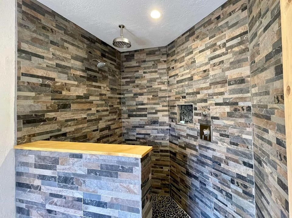 Master bathroom walk-in shower with regular and rainfall shower heads.