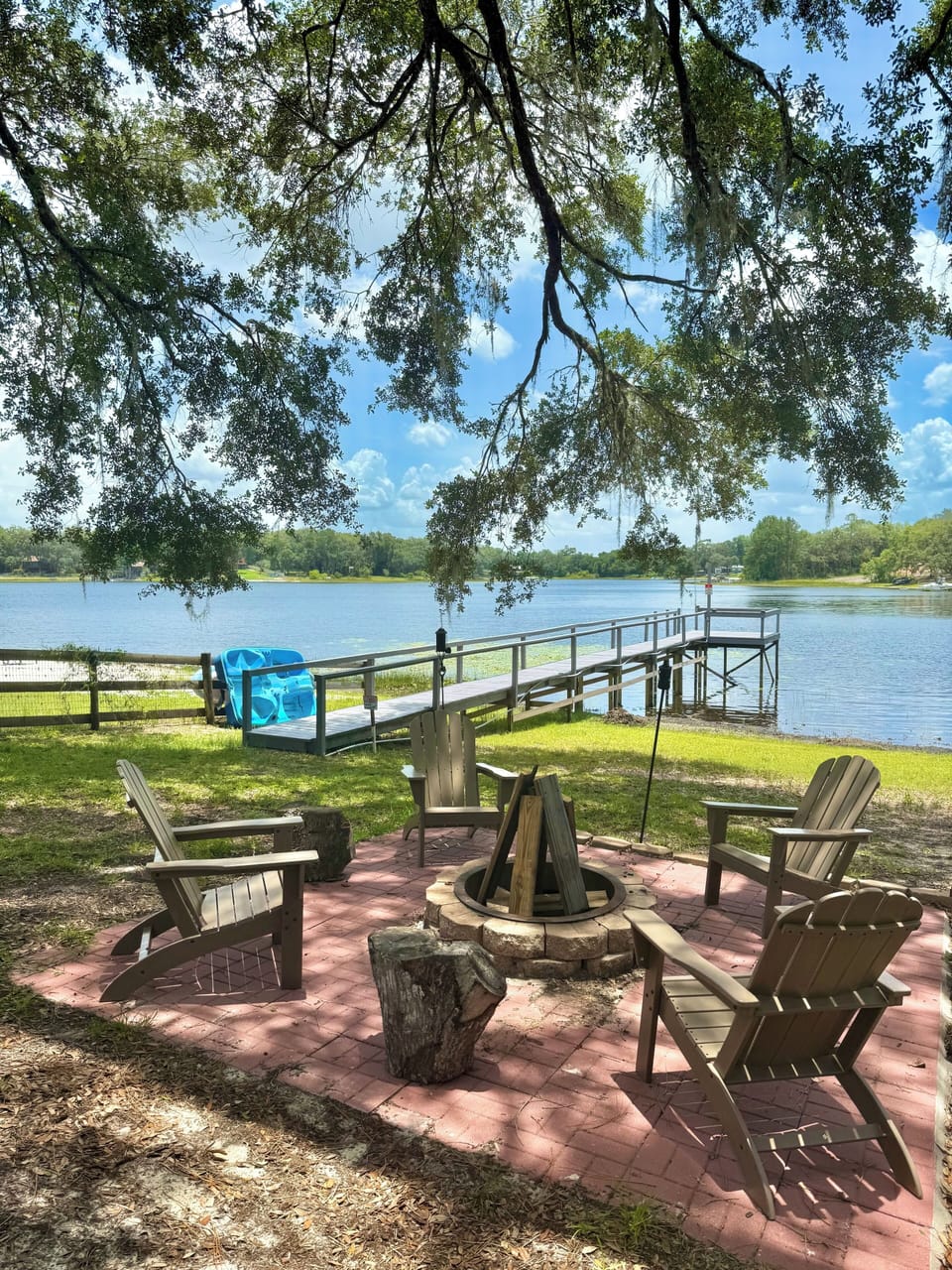 Fire pit with dock and paddle boat in backyard.