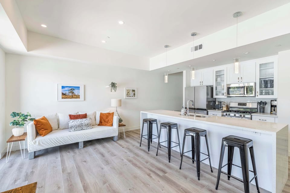 Open kitchen and living area with views, dining table and bar seating