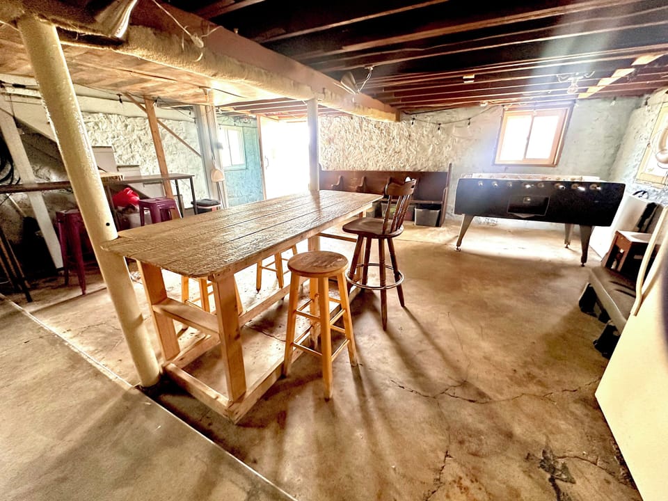 Basement features foosball, bar area, refrigerator, laundry & bathroom