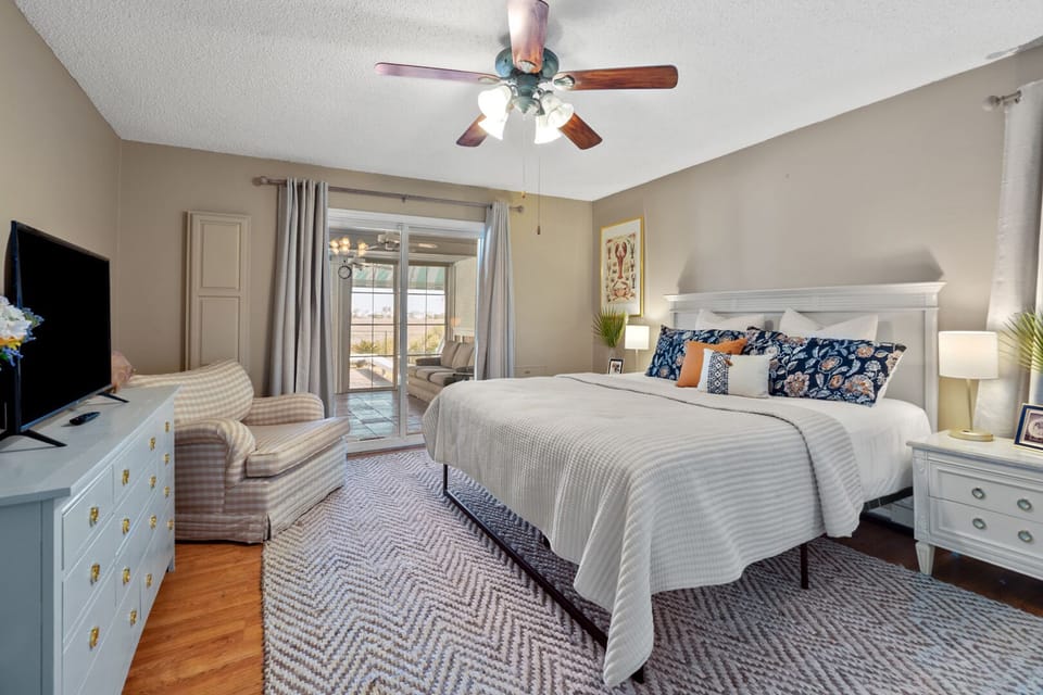 Bedroom with an armchair and a patio door at The Gritz Carlton, a 3-bedroom Cherry Grove rental