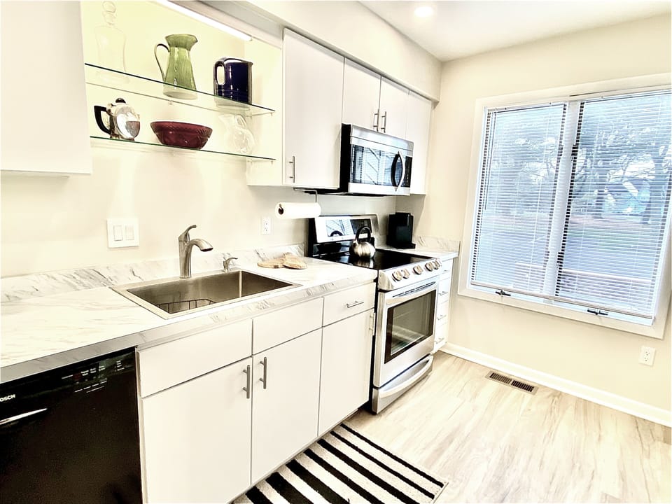 Fully equipped kitchen — stainless steel appliances, breakfast bar, and everything you need to whip up a local Delaware seafood feast.