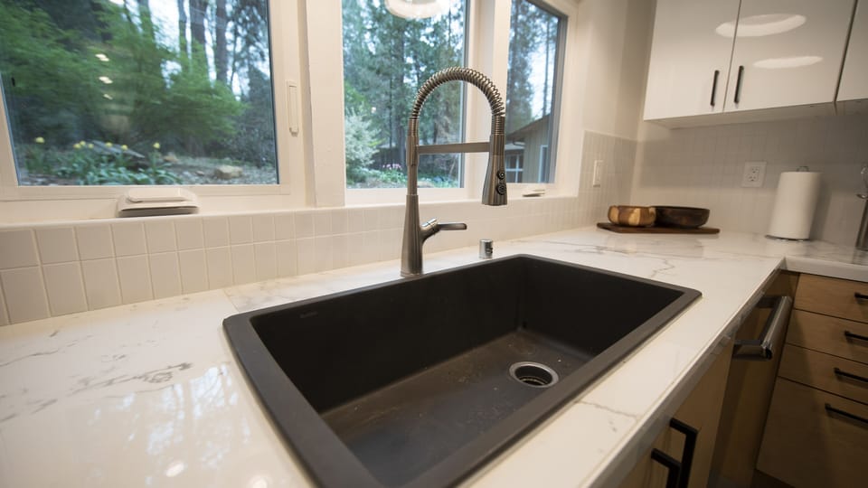 Large sink makes washing up easy with views of the landscaped yard.