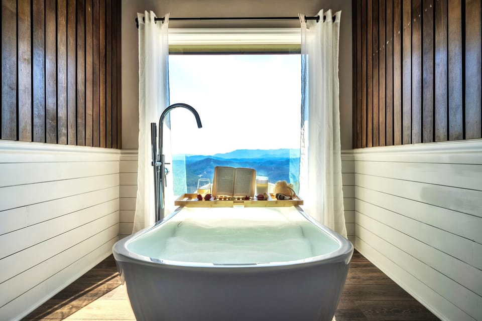 Sink into the soaking tub and let the Smoky Mountains steal the show, with floor-to-ceiling windows framing breathtaking views for a truly relaxing mountain escape.