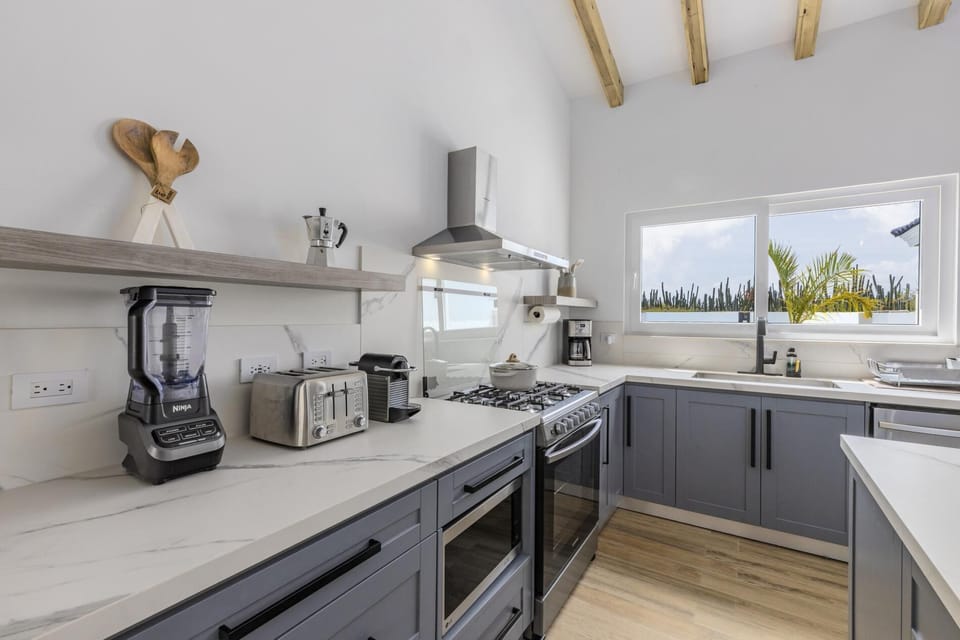 Prepare a delicious meal with your family in this full kitchen equipped with a large fridge, a stove, an oven, a blender, a coffee maker, and a toaster.