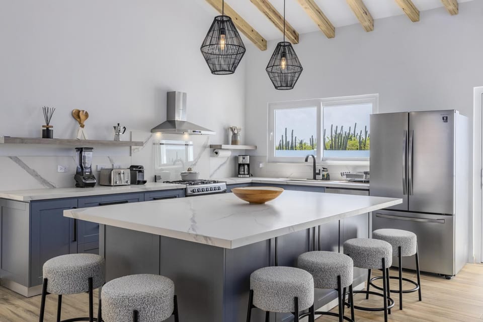 Prepare a delicious meal with your family in this full kitchen equipped with a large fridge, a stove, an oven, a blender, a coffee maker, and a toaster.
