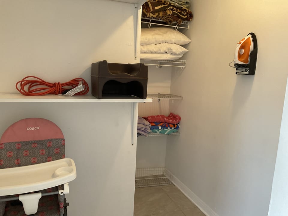 Walk in Closet  with High Chair, Iron, Iron Board, Booster Seat, and Bedding