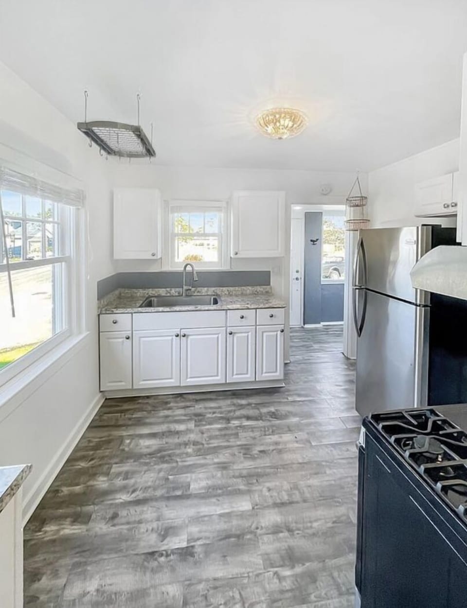 Bright & light kitchenette w/ updated kitchen sink & cupboards; newer floor