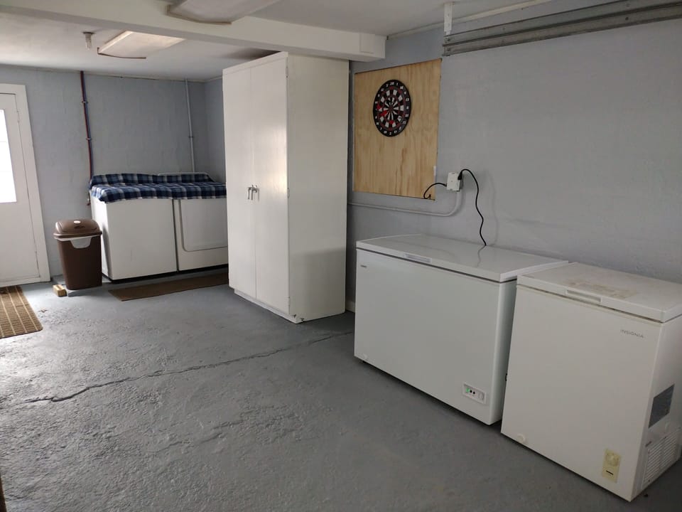 New washer, dryer and two chest freezers in garage area . 