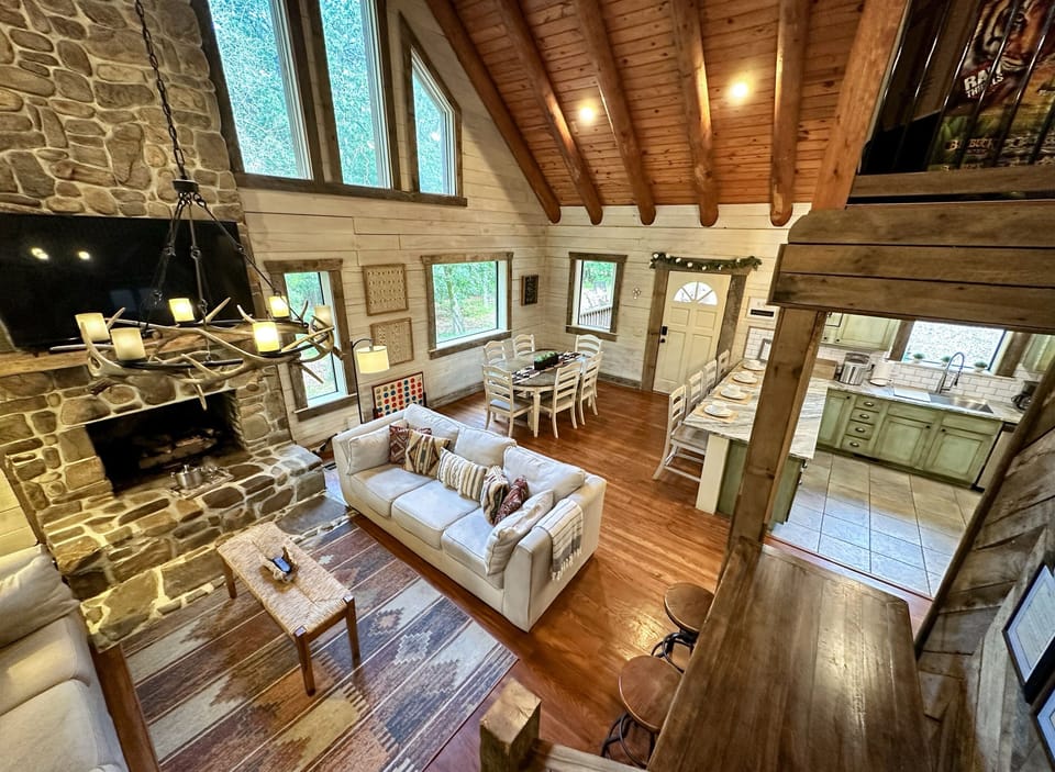 With its soaring ceilings, cozy stone fireplace, and warm wooden accents, this inviting space is perfect for family gatherings or a romantic getaway.
