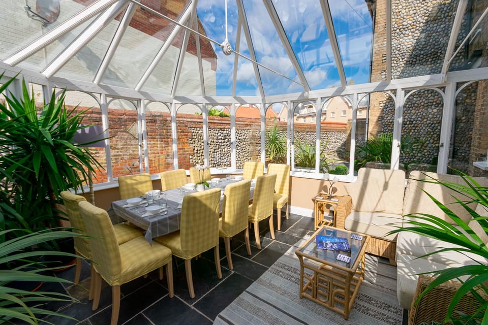 The sunny conservatory is full of plants and a great spot for coffee or drinks.