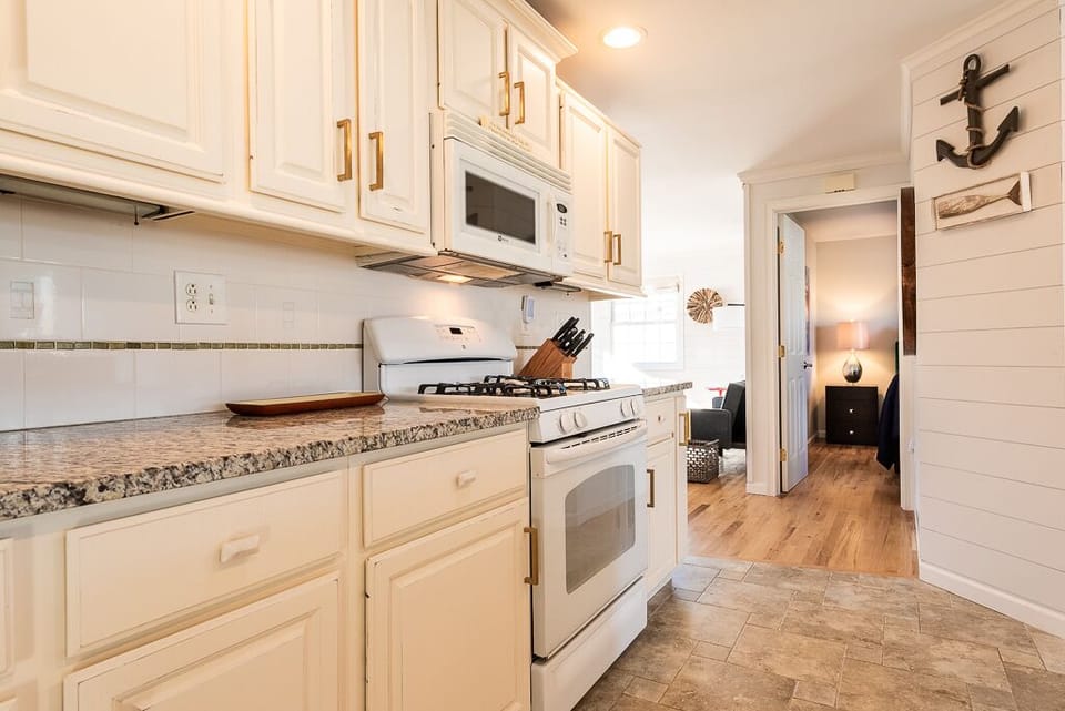 Kitchen with gas range & microwave, view to 2nd bedroom