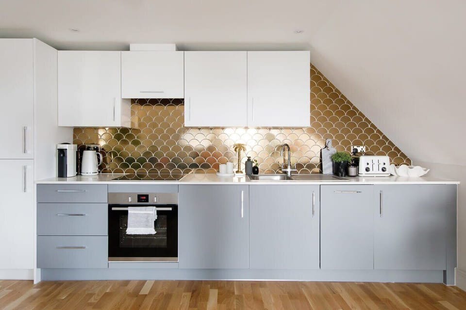 The north wall of the penthouse is covered with a contemporary, fully equipped kitchen.