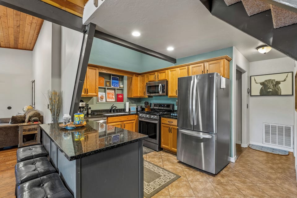 Fully equipped kitchen featuring stainless steel appliances, a spacious island with seating, and everything you need to prepare meals for family and friends.