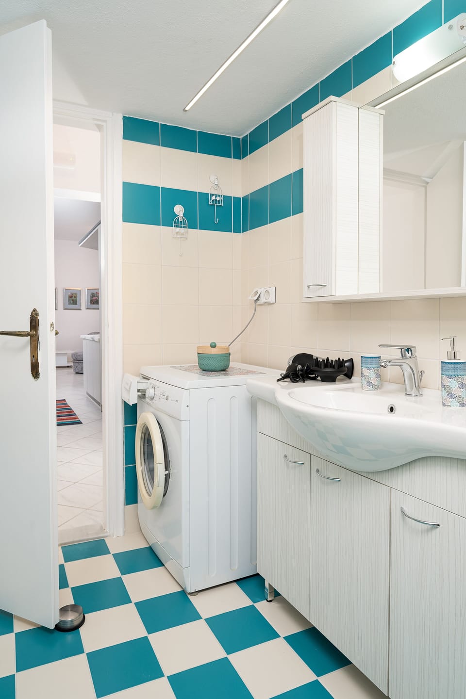 Bathroom, washing machine, hair dryer and sink.