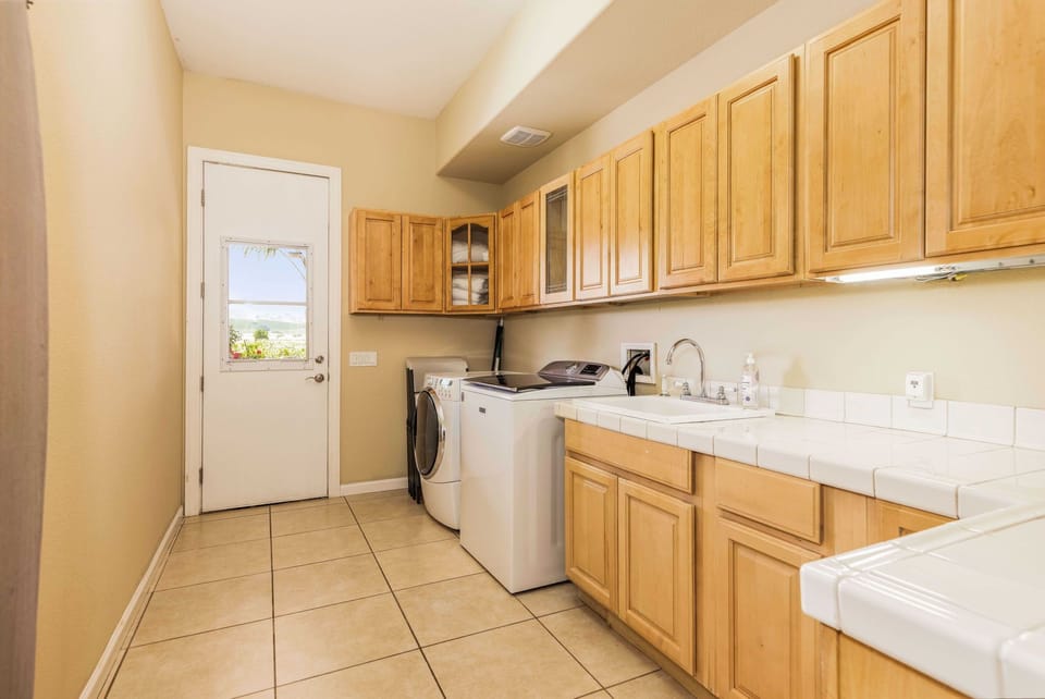 Laundry room with washer / dryer, iron and ironing board for guests.