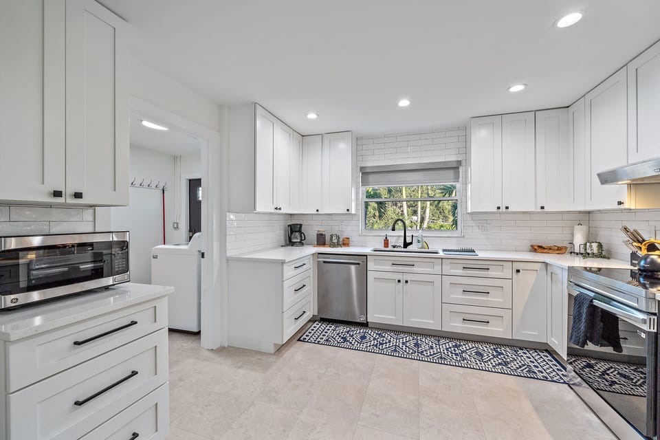 This spacious, fully-equipped kitchen is a chef's dream! You can see the entry door through the laundry room on the left.