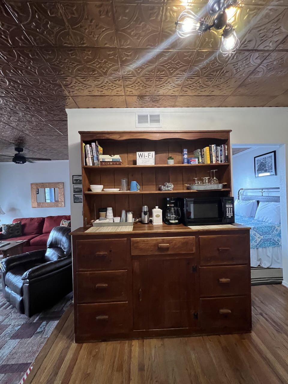 Kitchenette with coffebeans, grinder, coffee pot, sugar, creamer, and microwave
