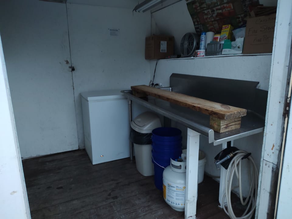 fish cleaning station in building and three freezers.