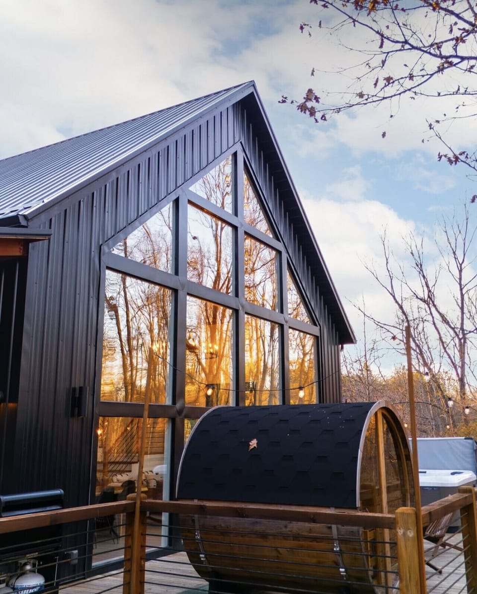 A 6-person Scandinavian barrel sauna overlooking the lush forest on property.