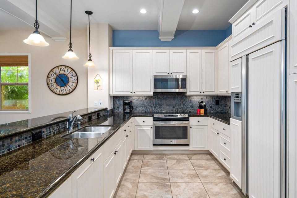 Full kitchen with breakfast bar, granite counters, and stainless steel appliances
