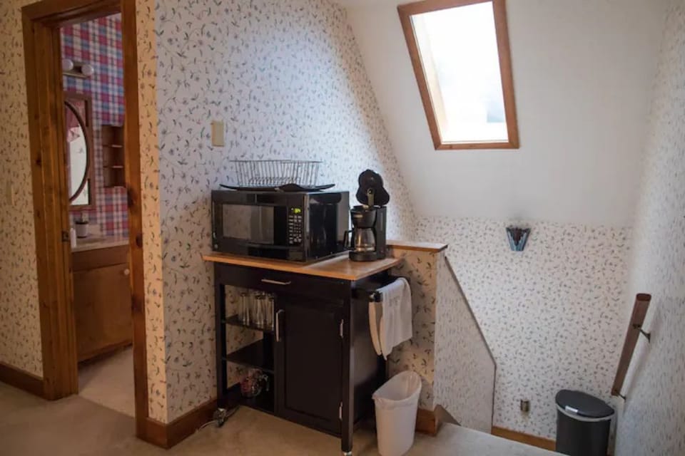 Microwave with coffee maker, toaster oven, crockpot and silverware, dishes.