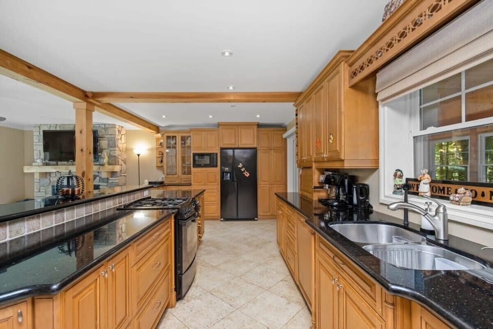 Kitchen with fridge, wine rack, oven, stove, microwave