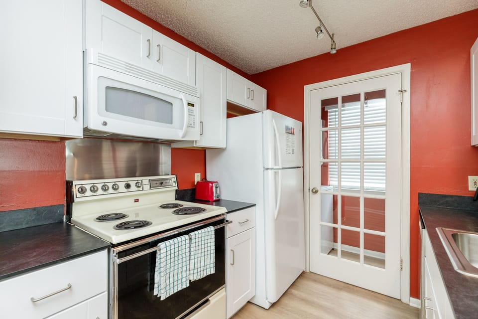 Your fully equipped kitchen features white cabinets, dark countertops, and all the essentials for preparing meals during your stay.