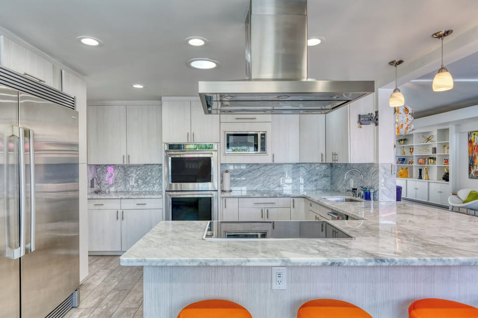 Gather around the stylish kitchen bar with seating for four. Featuring stainless steel appliances, sleek countertops, and ample cabinet space, it's the perfect space to cook and gather with family and friends, creating delicious memories together.