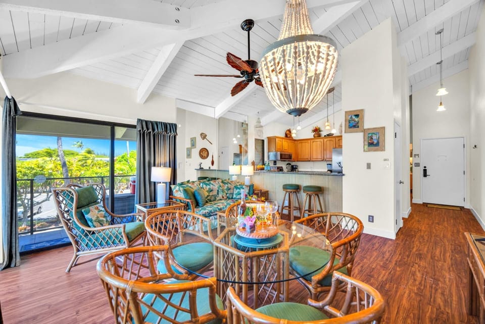 Open-concept layout with vaulted ceilings, stylish chandelier, and seamless flow from kitchen to lanai—ideal for entertaining.